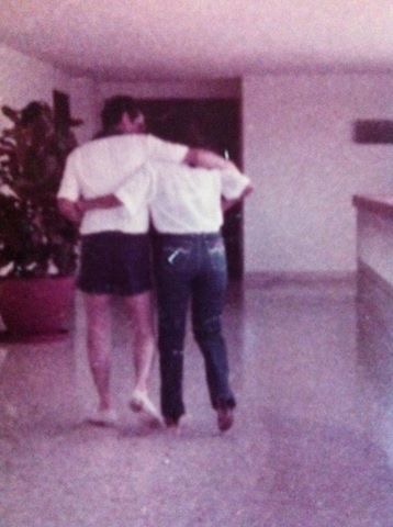 A family photograph from childhood — two people walking arm in arm.